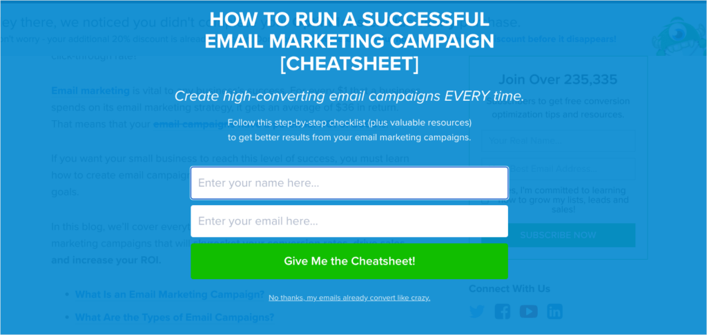 OptinMonster fullscreen website popup that says "How to Run a Successful Email Marketing Campaign [Cheatsheet] Create high-converting email campaigns EVERY time." Fields ask for name and email address. CTA button reads "Give Me the Cheatsheet!"